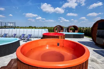an orange tub sitting on a patio next to a pool at Fantazja Resort Zator in Zator