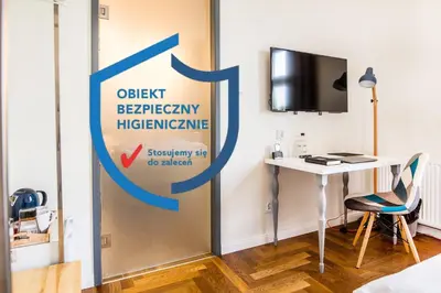 a sign for a desk and a television in a room at Tomasza 26 Old Town Suites in Kraków