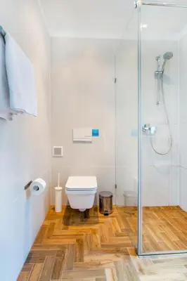 a bathroom with a toilet and a glass shower at Tomasza 26 Old Town Suites in Kraków