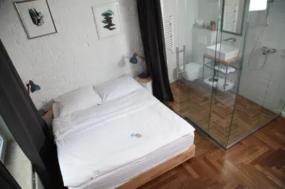 a small bedroom with a bed and a shower at Tomasza 26 Old Town Suites in Kraków