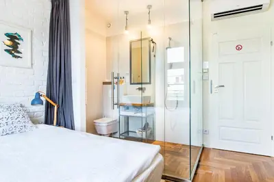 a bedroom with a bed and a glass shower at Tomasza 26 Old Town Suites in Kraków