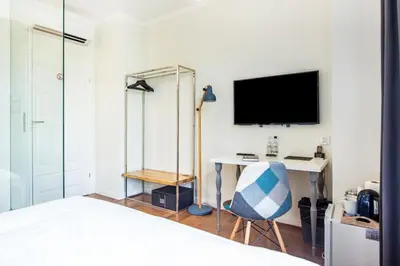 a bedroom with a bed and a desk and a tv at Tomasza 26 Old Town Suites in Kraków