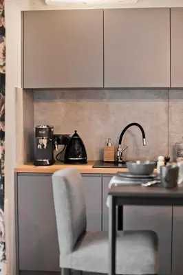 a kitchen with a sink and a table with a chair at Balaton Apartamenty in Trzebinia