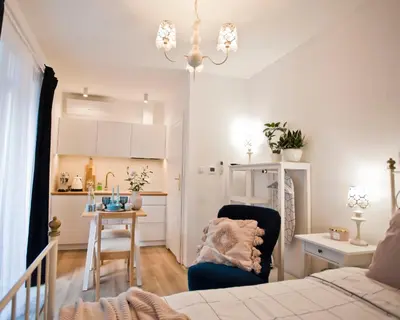 a living room with a bed and a kitchen at Balaton Apartamenty in Trzebinia