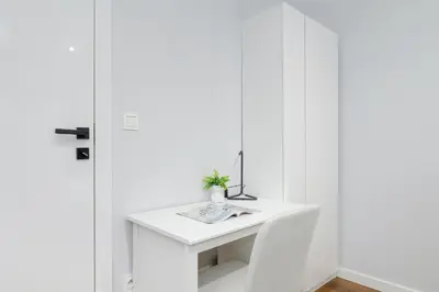 a white desk in a room with white walls at Ślusarska Modern Apartment with Balcony & Parking Cracow Zabłocie by Renters Prestige in Kraków