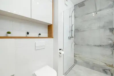 a bathroom with a shower with a glass door at Ślusarska Modern Apartment with Balcony & Parking Cracow Zabłocie by Renters Prestige in Kraków