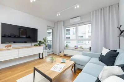 a living room with a blue couch and a tv at Ślusarska Modern Apartment with Balcony & Parking Cracow Zabłocie by Renters Prestige in Kraków