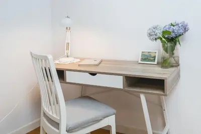 a desk with a chair and a vase of flowers at Unique Spacious 3 Bedroom Apartment - Old Town Loft - by Upstairs in Kraków