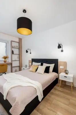 a bedroom with a large bed with a black headboard at Royal Center Apartments in Kraków