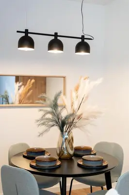 a dining room table with plates and a vase with feathers at Royal Center Apartments in Kraków