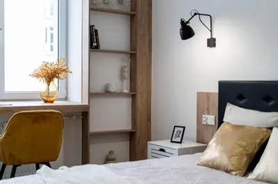 a bedroom with a bed and a desk and a chair at Royal Center Apartments in Kraków