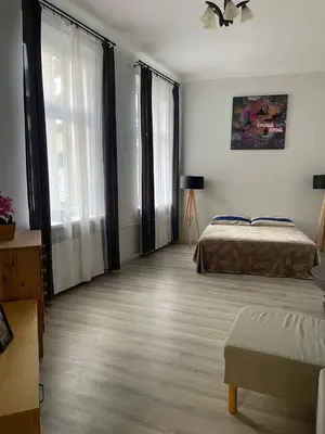a bed in a room with two lamps and a painting at OLD KRAKOV in Kraków