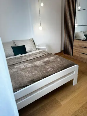 a bedroom with a white bed and a mirror at Apartament na Orkana in Rabka-Zdroj