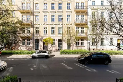two cars parked in front of a large building at San Sebastian - beauty&silence in Kraków