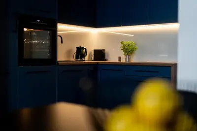 a kitchen with blue cabinets and a counter top at San Sebastian - beauty&silence in Kraków