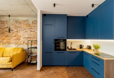 a kitchen with blue cabinets and a yellow couch at San Sebastian - beauty&silence in Kraków