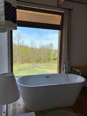 a large white bath tub in front of a window at Rogaty Domek nad Zalewem in Dobczyce