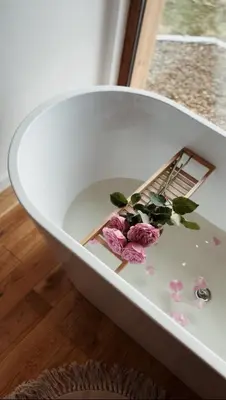 a white bowl with flowers in it on the floor at Rogaty Domek nad Zalewem in Dobczyce