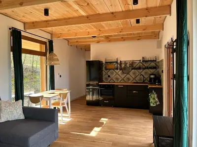 a kitchen and living room with a couch and a table at Rogaty Domek nad Zalewem in Dobczyce