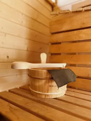 a wooden tub in a sauna with a wooden spoon at Rogaty Domek nad Zalewem in Dobczyce