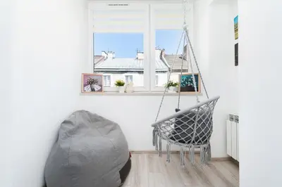 a room with a chair and a window at Vistula River Apartment in Kraków