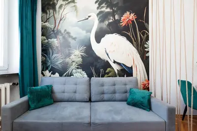 a couch in a living room with a painting of a bird at Vistula River Apartment in Kraków