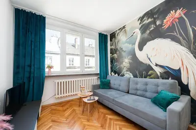 a living room with a large mural of a large bird at Vistula River Apartment in Kraków