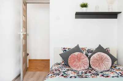 a bedroom with a bed with pillows on it at Vistula River Apartment in Kraków
