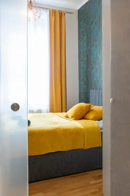 a bedroom with a bed with yellow sheets and a window at Grzegórzki Studio - Main Station & Parks nearby - by Rentujemy in Kraków