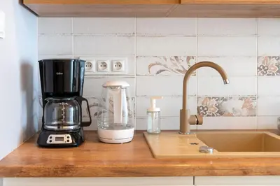 a kitchen counter with a coffee maker on a counter top at Grzegórzki Studio - Main Station & Parks nearby - by Rentujemy in Kraków