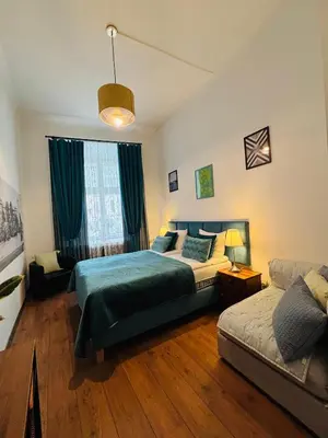 a red couch with two pillows on it at Krakow Apartments & Rooms in Kraków