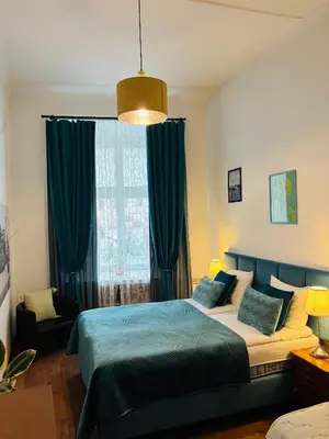 a bedroom with a bed with yellow curtains at Krakow Apartments & Rooms in Kraków