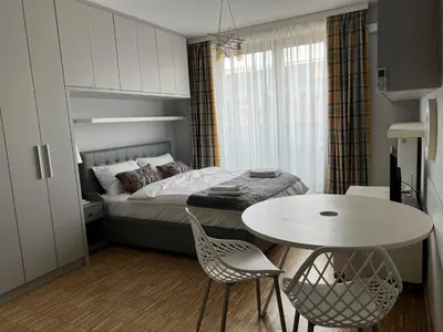 a bedroom with a bed and a table and chairs at Angel City Apartament in Kraków