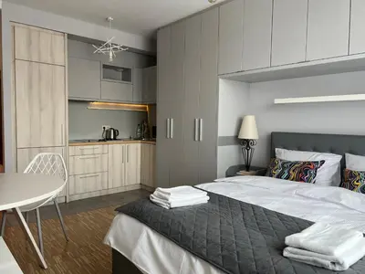 a bedroom with a large bed and a table at Angel City Apartament in Kraków