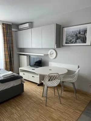 a room with a table and two chairs and a bed at Angel City Apartament in Kraków