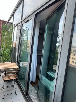 a balcony with glass doors and a table at Angel City Apartament in Kraków