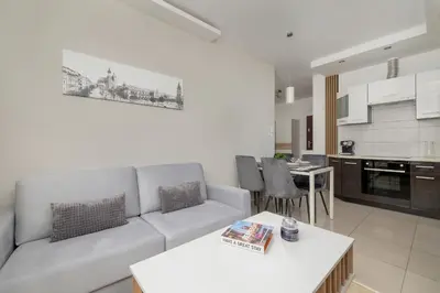 a living room with a couch and a kitchen at Podgórze Air-Conditioned Family Apartment with Parking by Noclegi Renters in Kraków