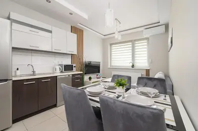 a kitchen and dining room with a table and chairs at Podgórze Air-Conditioned Family Apartment with Parking by Noclegi Renters in Kraków