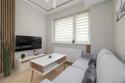 a living room with a couch and a table at Podgórze Air-Conditioned Family Apartment with Parking by Noclegi Renters in Kraków