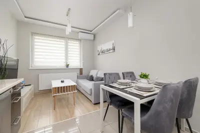 a living room with a table and a couch at Podgórze Air-Conditioned Family Apartment with Parking by Noclegi Renters in Kraków