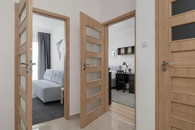 a room with a door and a living room at Podgórze Air-Conditioned Family Apartment with Parking by Noclegi Renters in Kraków