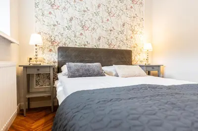 a bedroom with a bed and a floral wall at Vintage Bracka Apartment in Kraków