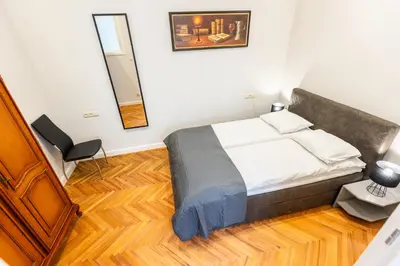 a bedroom with a bed and a mirror on the wall at Vintage Bracka Apartment in Kraków