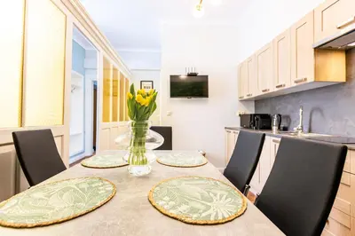 a kitchen with a table with plates and flowers on it at Vintage Bracka Apartment in Kraków