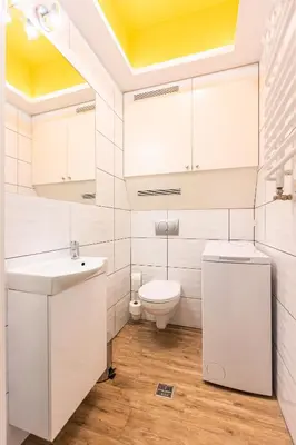 a white bathroom with a sink and a toilet at Vintage Bracka Apartment in Kraków