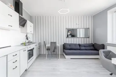 a kitchen and living room with a blue couch at Cegielniana Grey Studio by BookingHost in Kraków