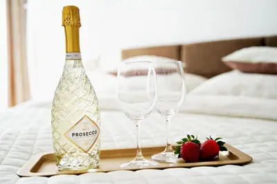 two wine glasses and two strawberries on a table at Apartament Bulwary 3 in Oświęcim