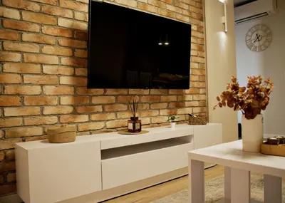 a living room with a tv on a brick wall at Apartament Bulwary 3 in Oświęcim