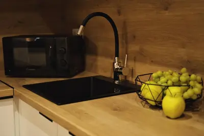 a kitchen counter with a sink and a bowl of grapes at Apartament Bulwary 3 in Oświęcim
