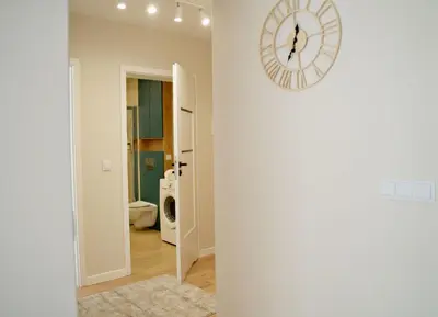 a clock on a wall next to a laundry room at Apartament Bulwary 3 in Oświęcim
